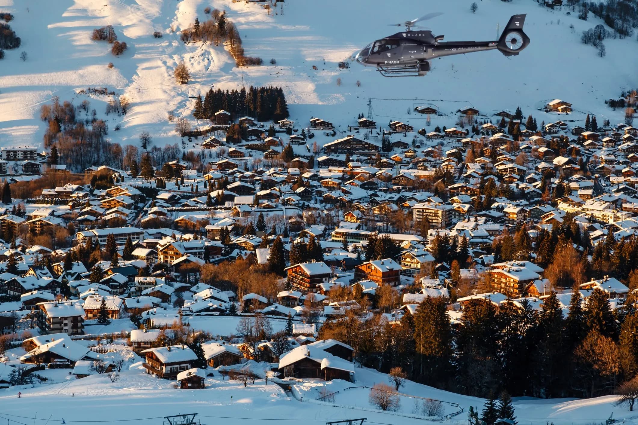 H130 Héli Sécurité survolant Megève sous la neige